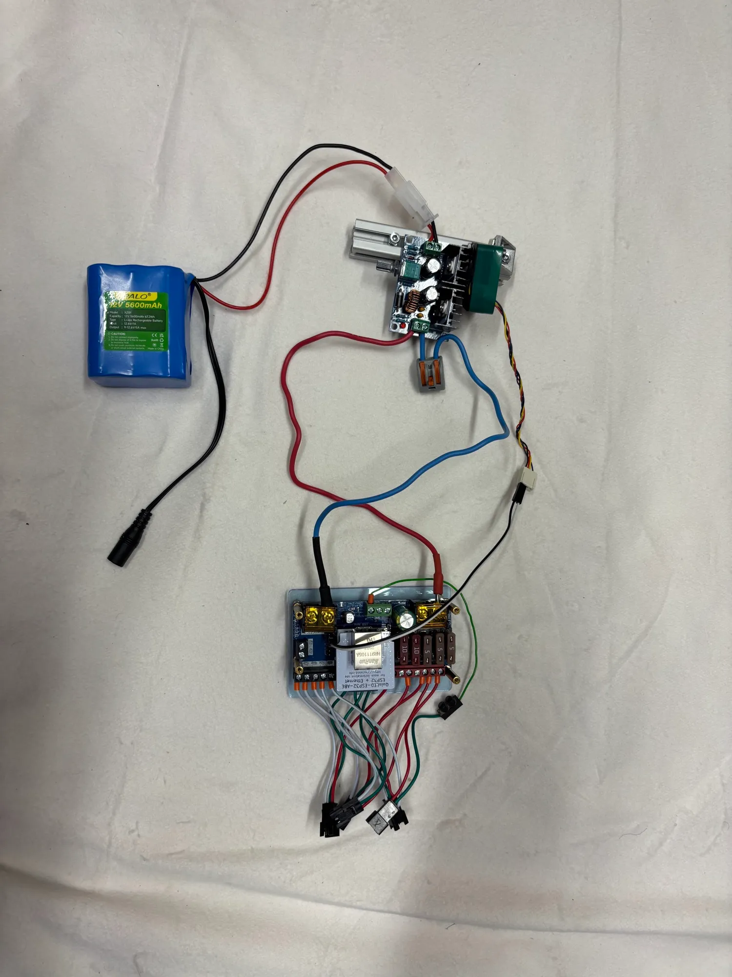 The complete electronics setup for the pilot: Cityork battery, DollaTek buck converter and QuinLED Dig-Quad controller laid out on the bench.