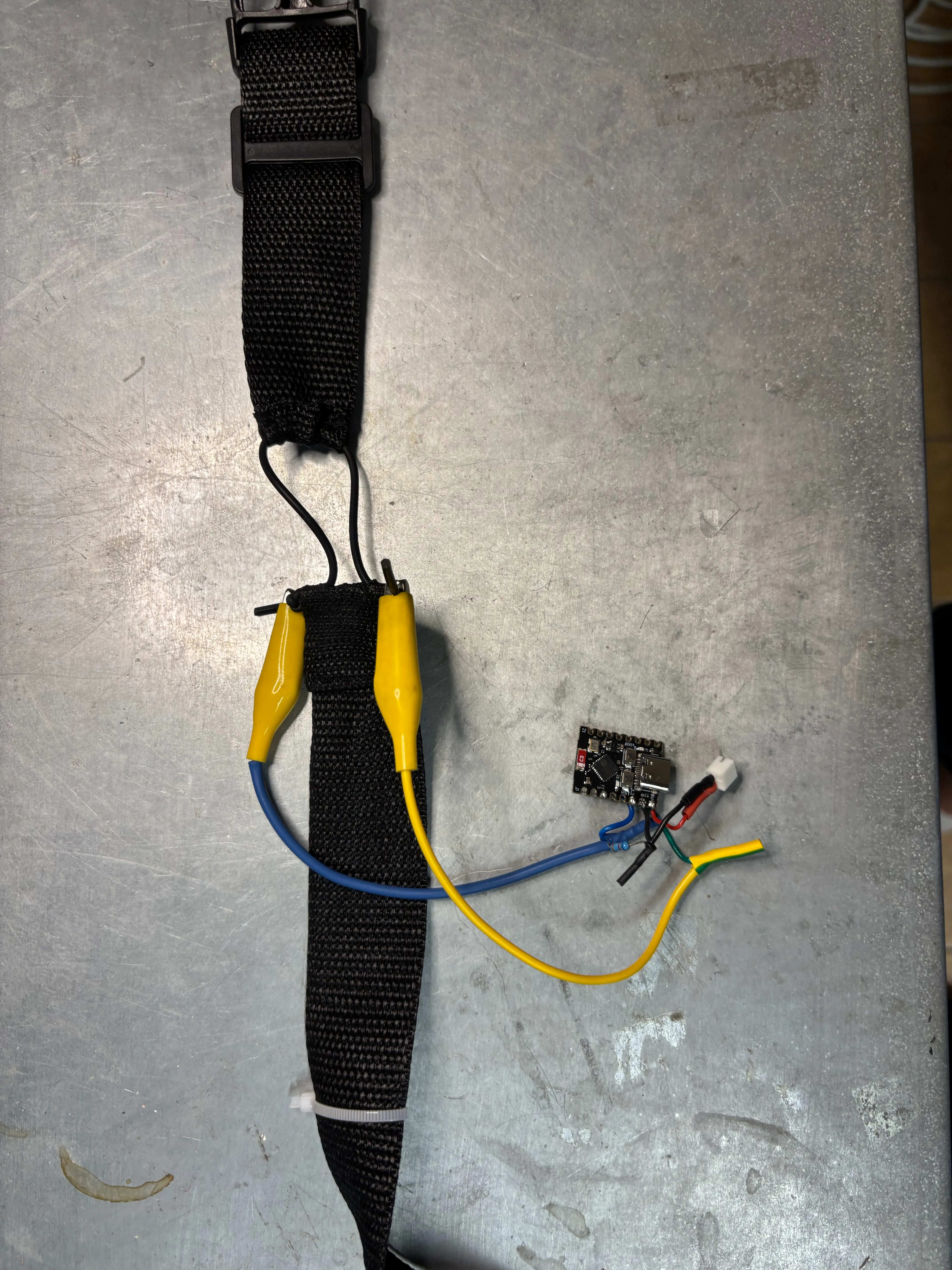 The wearable breathing belt prototype with stretch sensor, alligator clips, and ESP32-C3 microcontroller board.