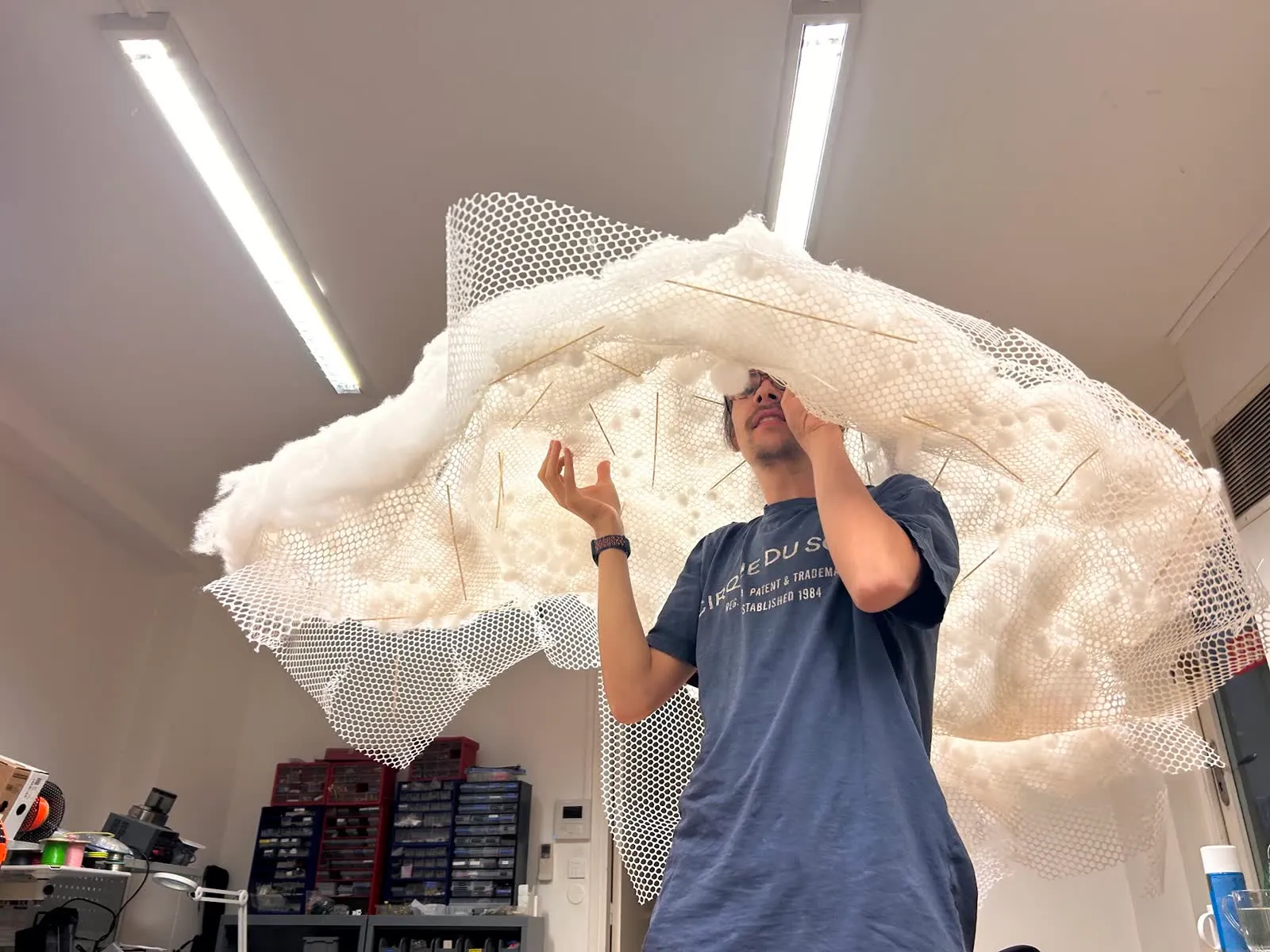 Holding up the fibre and mesh shell overhead to judge its shape