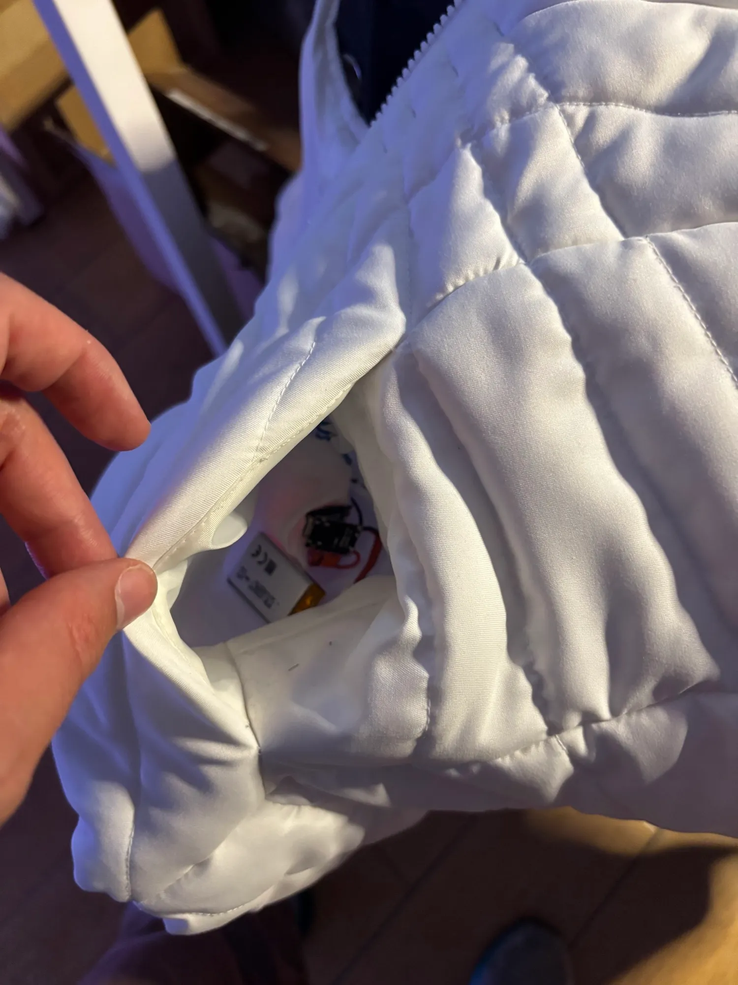 The wireless breathing sensor device tucked neatly into the chest pocket of the cloud jacket.