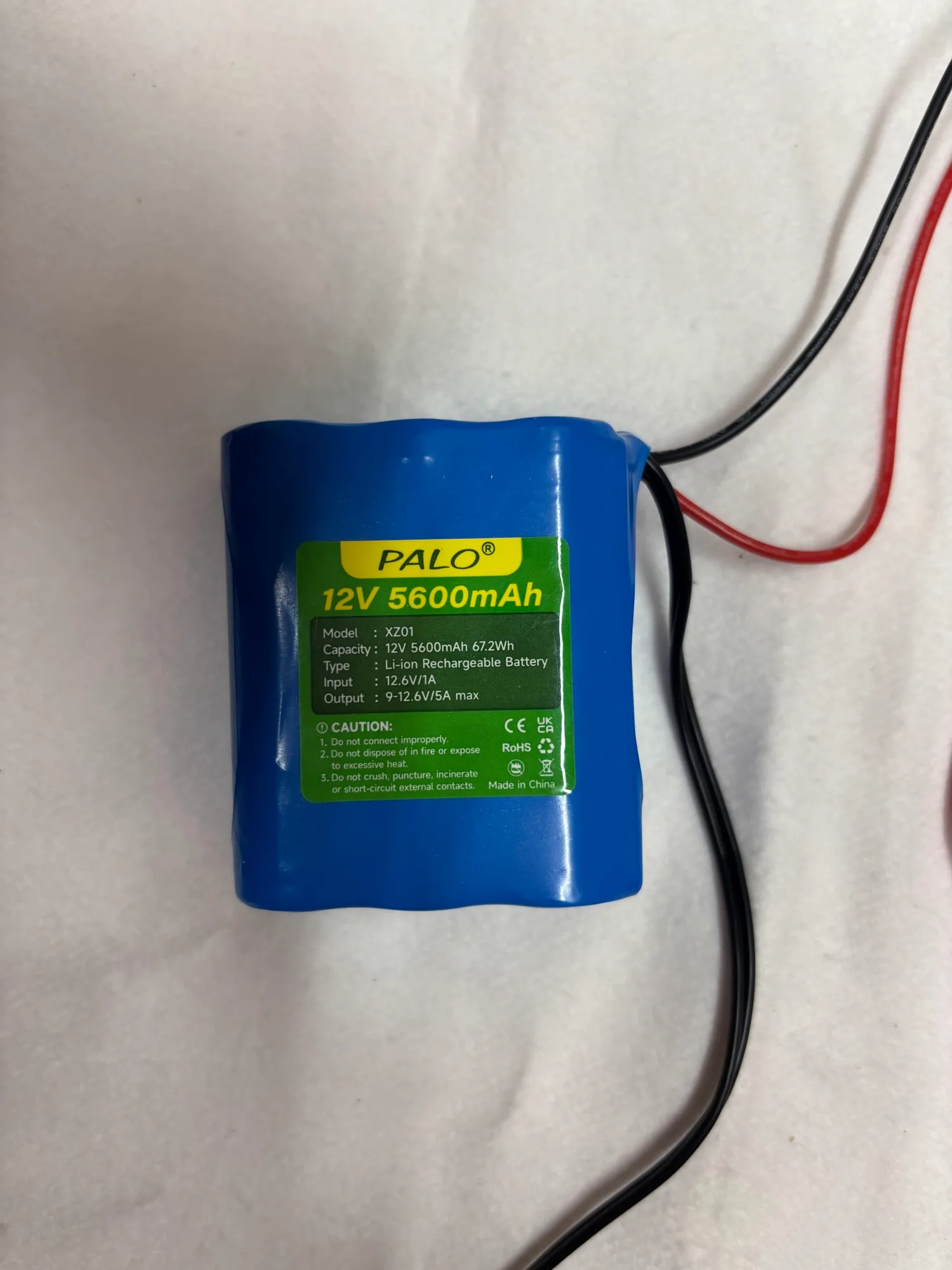 A blue lithium battery pack with red and black leads.