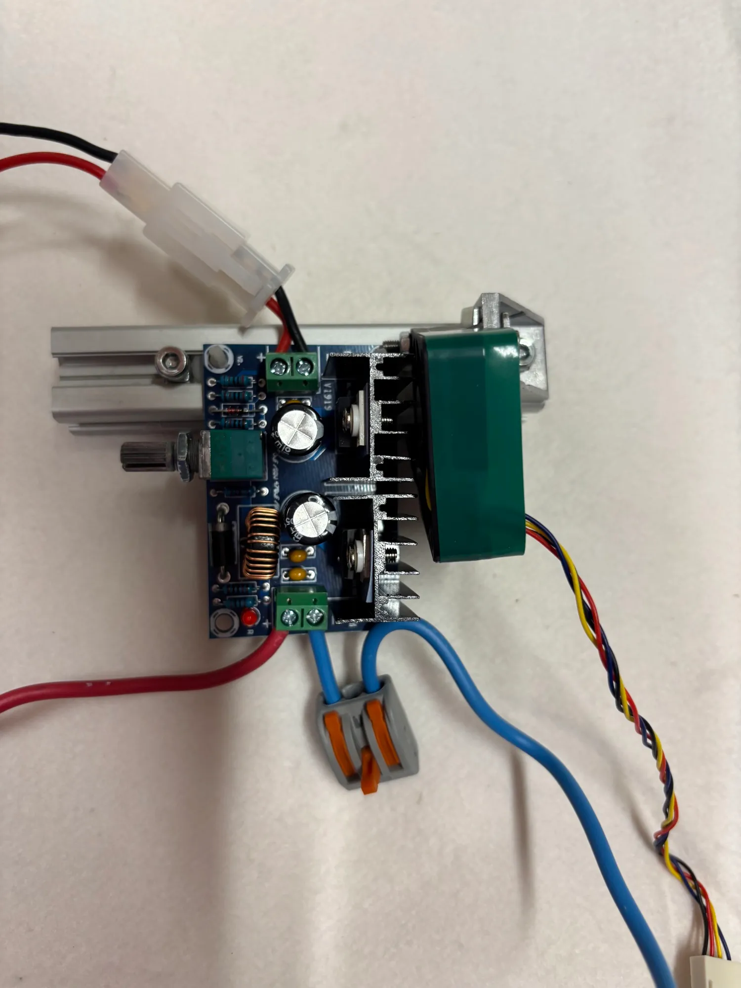 A buck converter module with a heat sink, wired with lever connectors.
