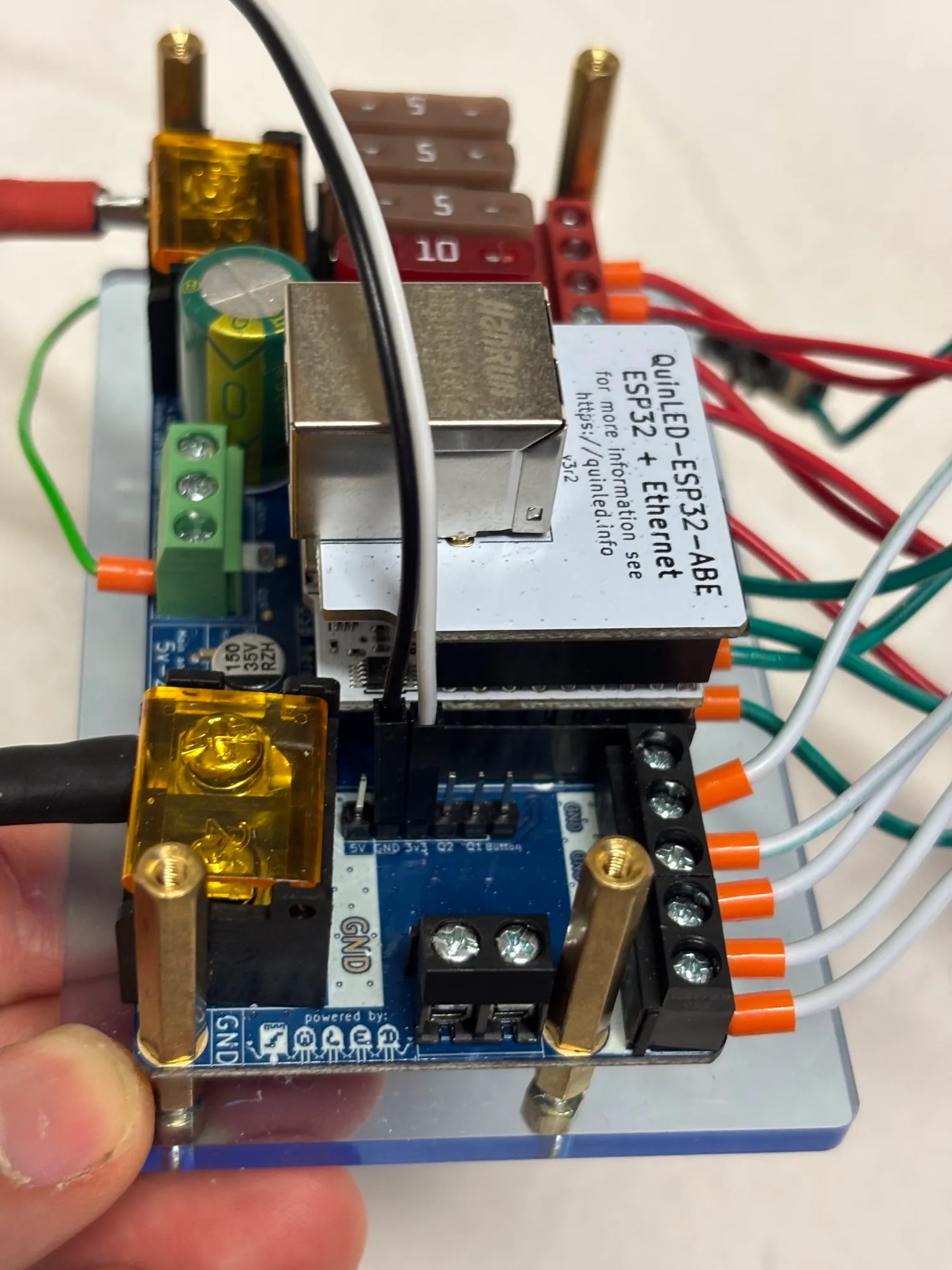An LED controller board on a small acrylic plate, with wires running off it.