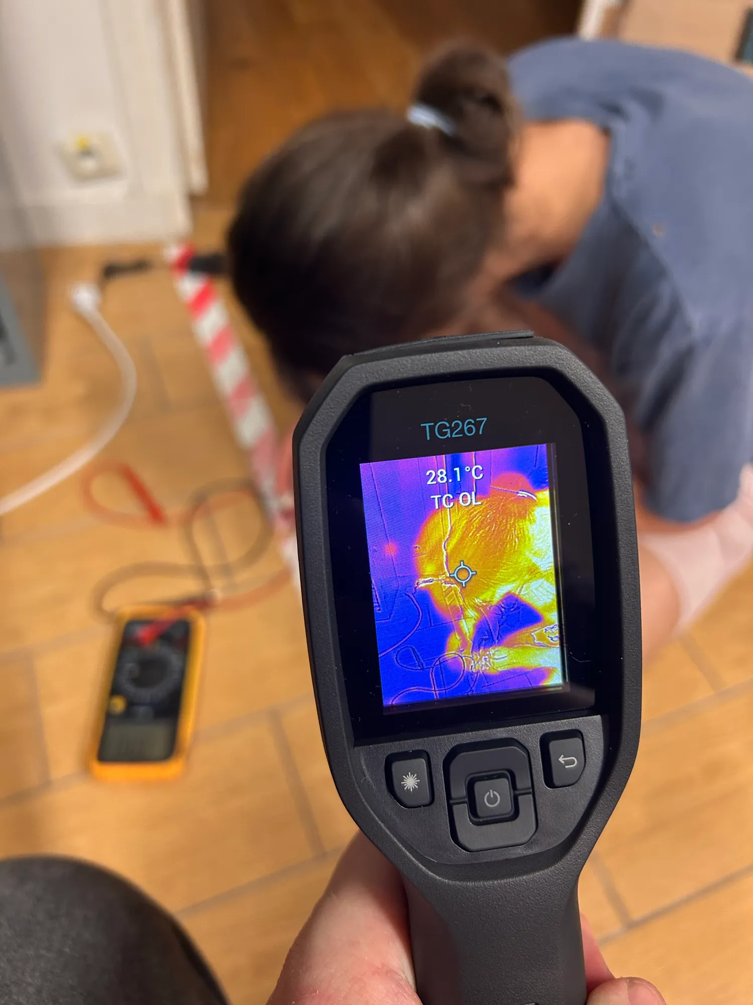 A thermal camera pointed at the electronics on the floor, showing a hot spot.