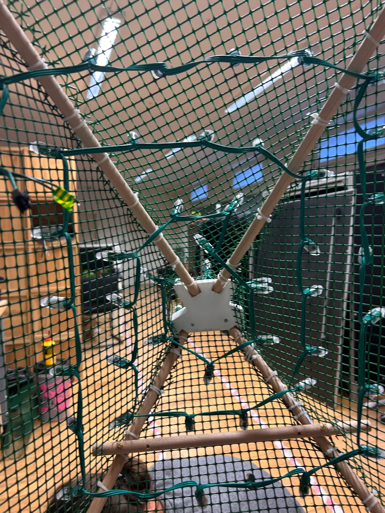Looking up inside the mesh-wrapped pyramid, with strings of LED pixels zip-tied in rows along each face.