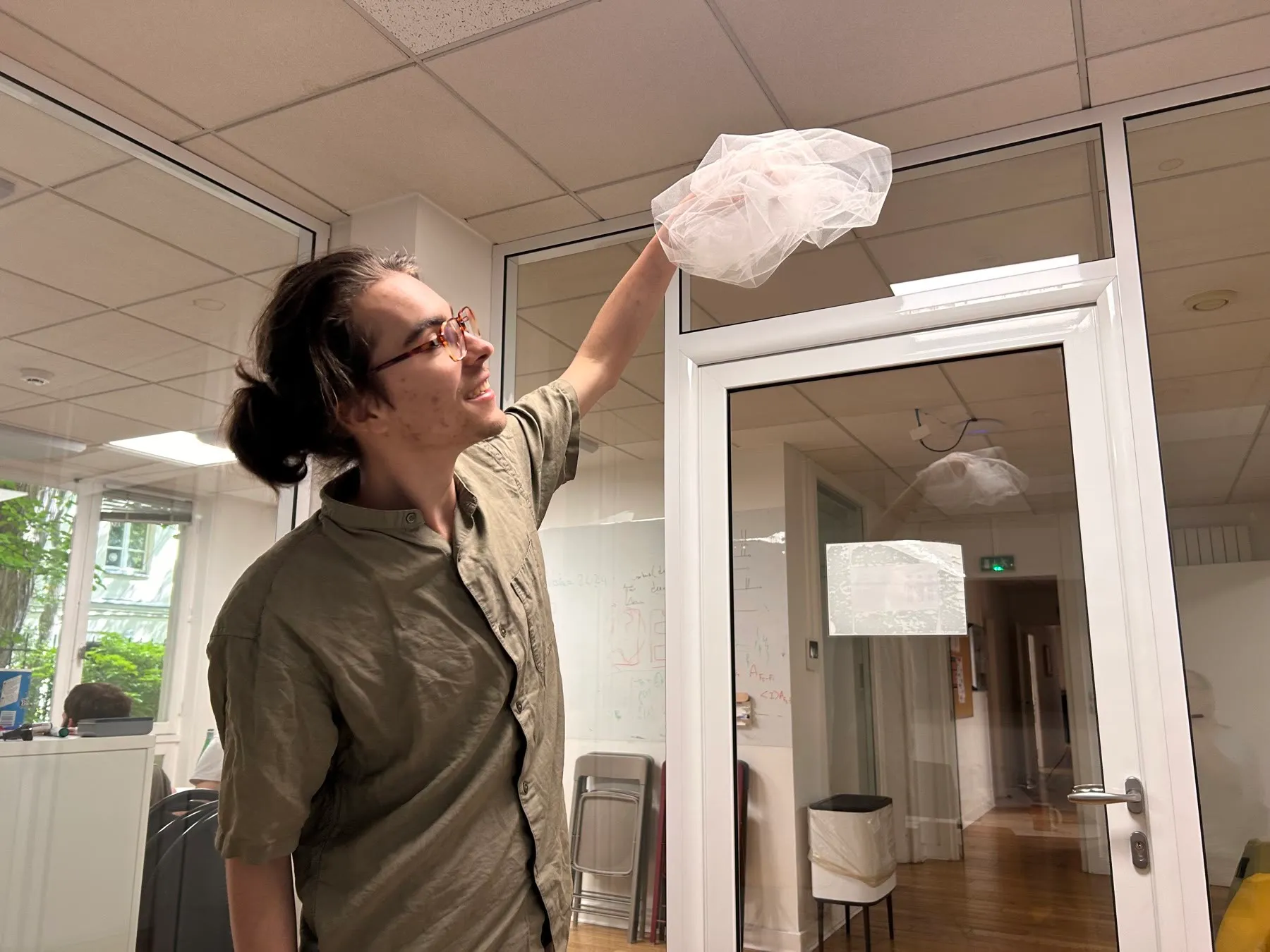 Zéphir holding up a bunched mass of white tulle, like a small cloud.